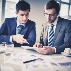 Image of two young businessmen discussing new project in office